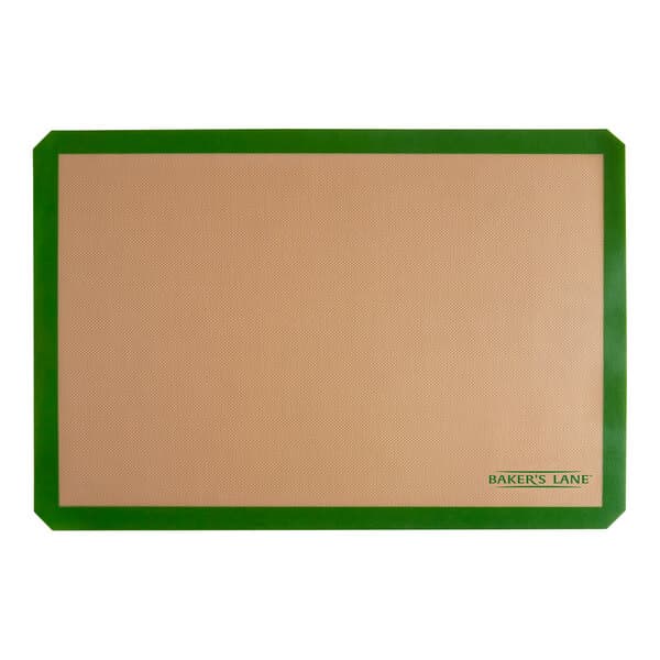 A tan rectangular Baker's Lane silicone baking mat with a green border.