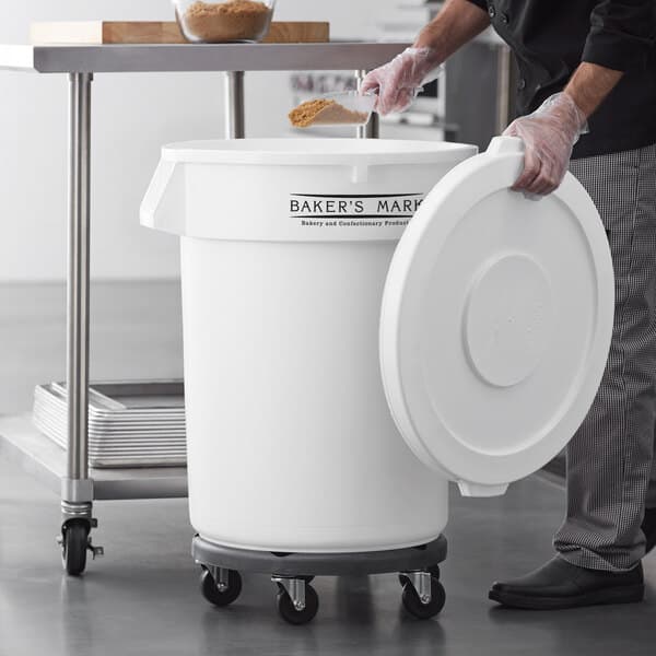 A person using a Baker's Mark white mobile ingredient storage container with a white lid.