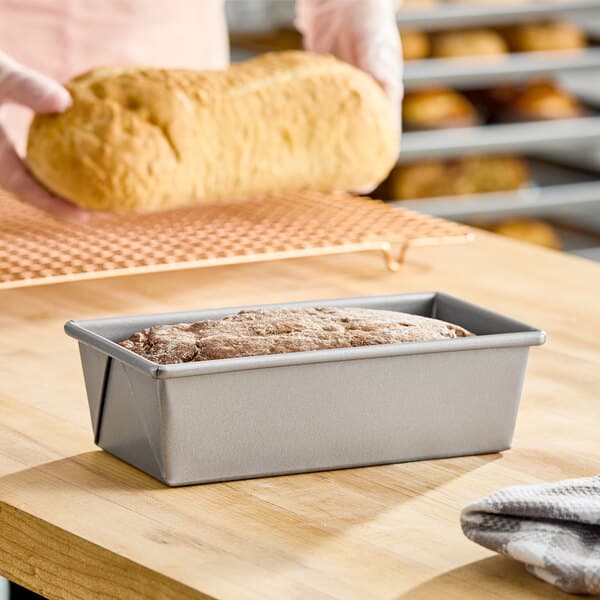 A rectangular glazed aluminized steel bread loaf pan measuring 8 inches by 4 inches by 2.5 inches.
