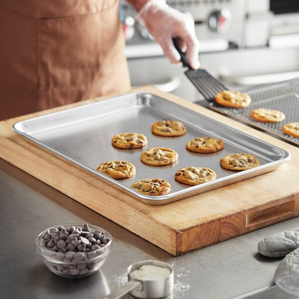 A person baking cookies on a Baker's Mark aluminum sheet pan.