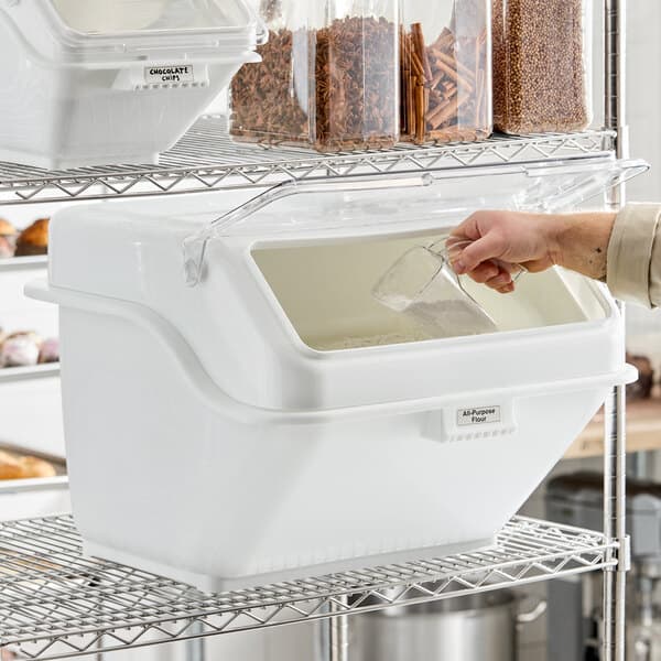 A large white ingredient bin with a flip lid and scoop, designed for bulk storage on a wire shelf.