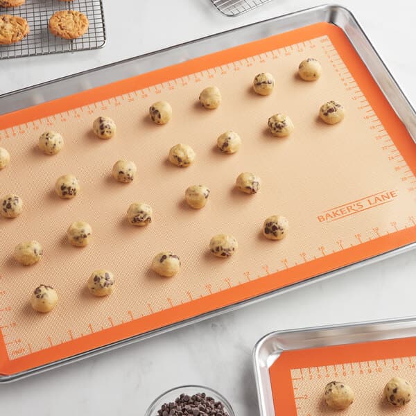 A Baker's Lane baking mat on a baking sheet with cookies.