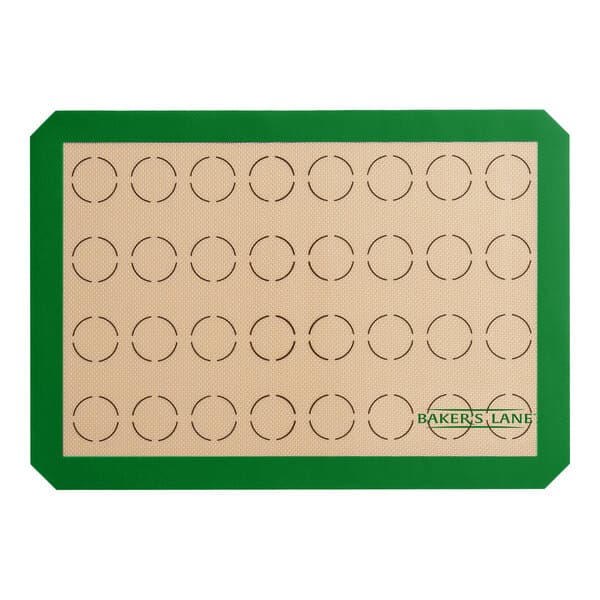 A green and white Baker's Lane baking mat with circles for 32 macarons.