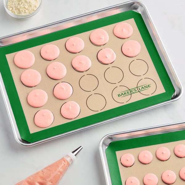 A tray of pink cookies on a Baker's Lane green silicone baking mat.