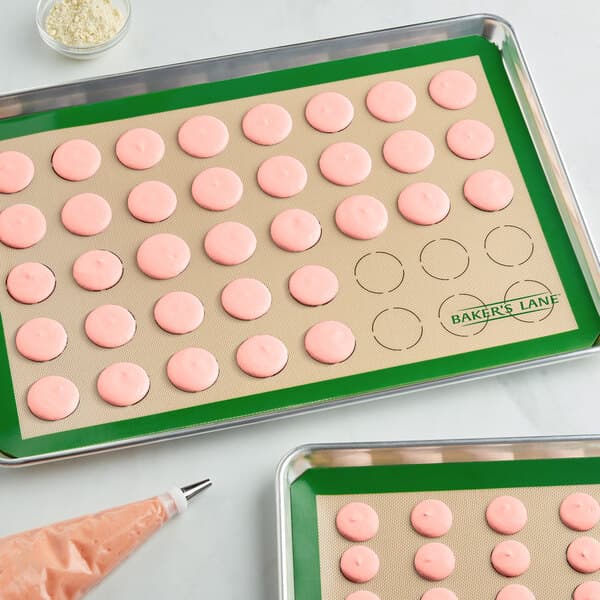 A Baker's Lane green silicone mat with macarons on it.
