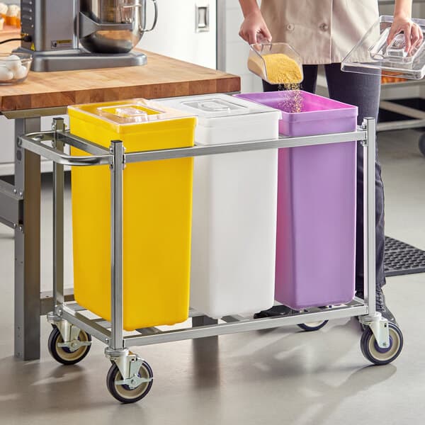 A mobile triple ingredient bin with yellow, white, and purple containers on a metal frame with wheels.