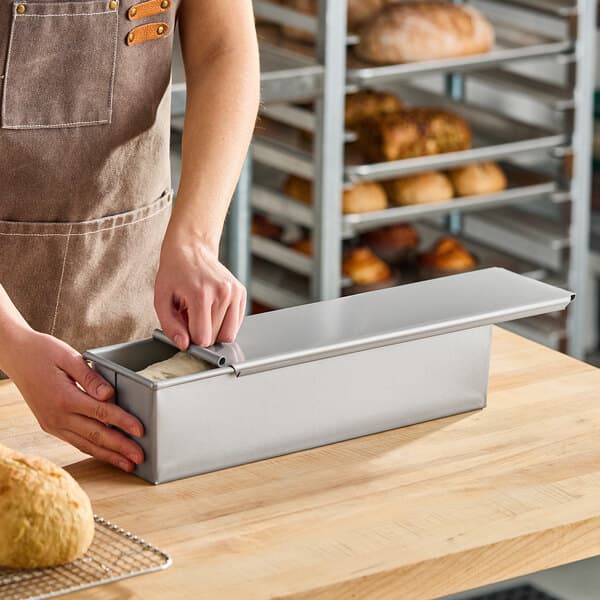 A 2 lb. glazed aluminized steel Pullman bread loaf pan with a sliding cover, measuring 16 x 4 x 4 inches.