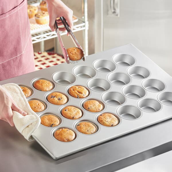 A woman using a Baker's Mark jumbo muffin pan to make muffins.