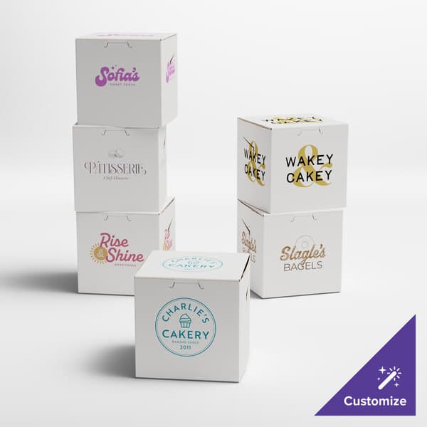 A group of white Baker's Lane bakery boxes with custom logos on them.