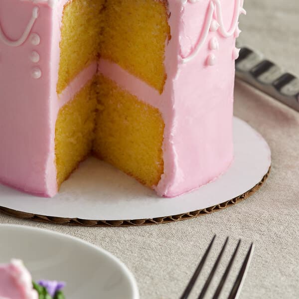 A cake on a white Baker's Mark cake circle sitting on a plate.