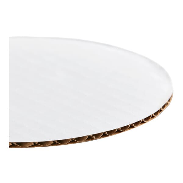A round, white, corrugated grease-resistant cake circle.