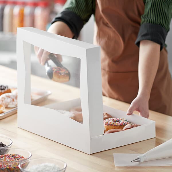 A white bakery box with a clear window, designed for holding donuts or pastries.