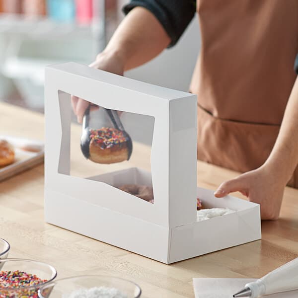 A white bakery box with a clear window on top, designed for holding donuts or baked goods.